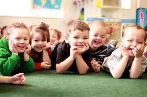 Smiling preschool kids laying on the floor